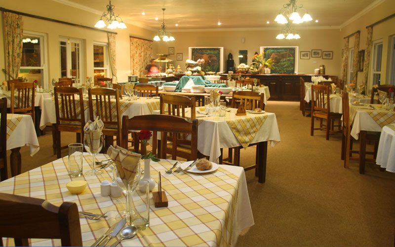 The dining room with laid tables, chandeliers and a buffet counter