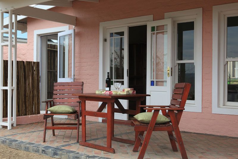 A small outdoor table set for two on a cottage patio
